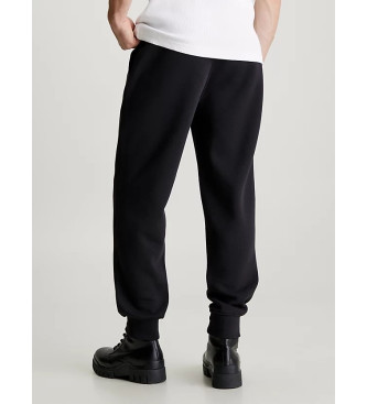 Calvin Klein Jeans Hlače trenirke Bombažne hlače iz flisa Hlače trenirke črne