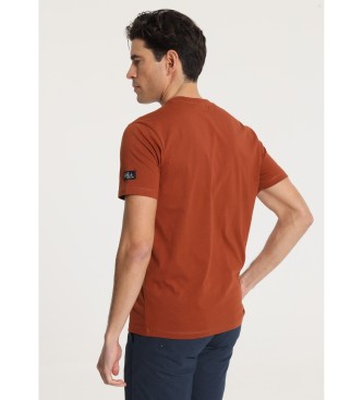 Victorio & Lucchino, V&L T-shirt met korte mouwen en bruinoranje cirkelvormig borstpatroon